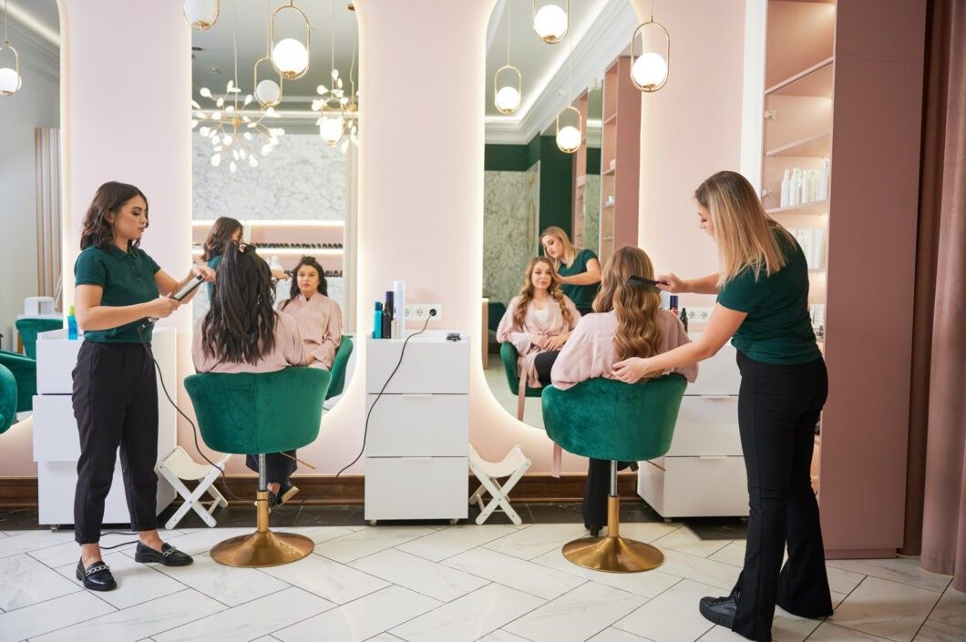 Dos peluqueras peinando a clientas en un salón de belleza moderno