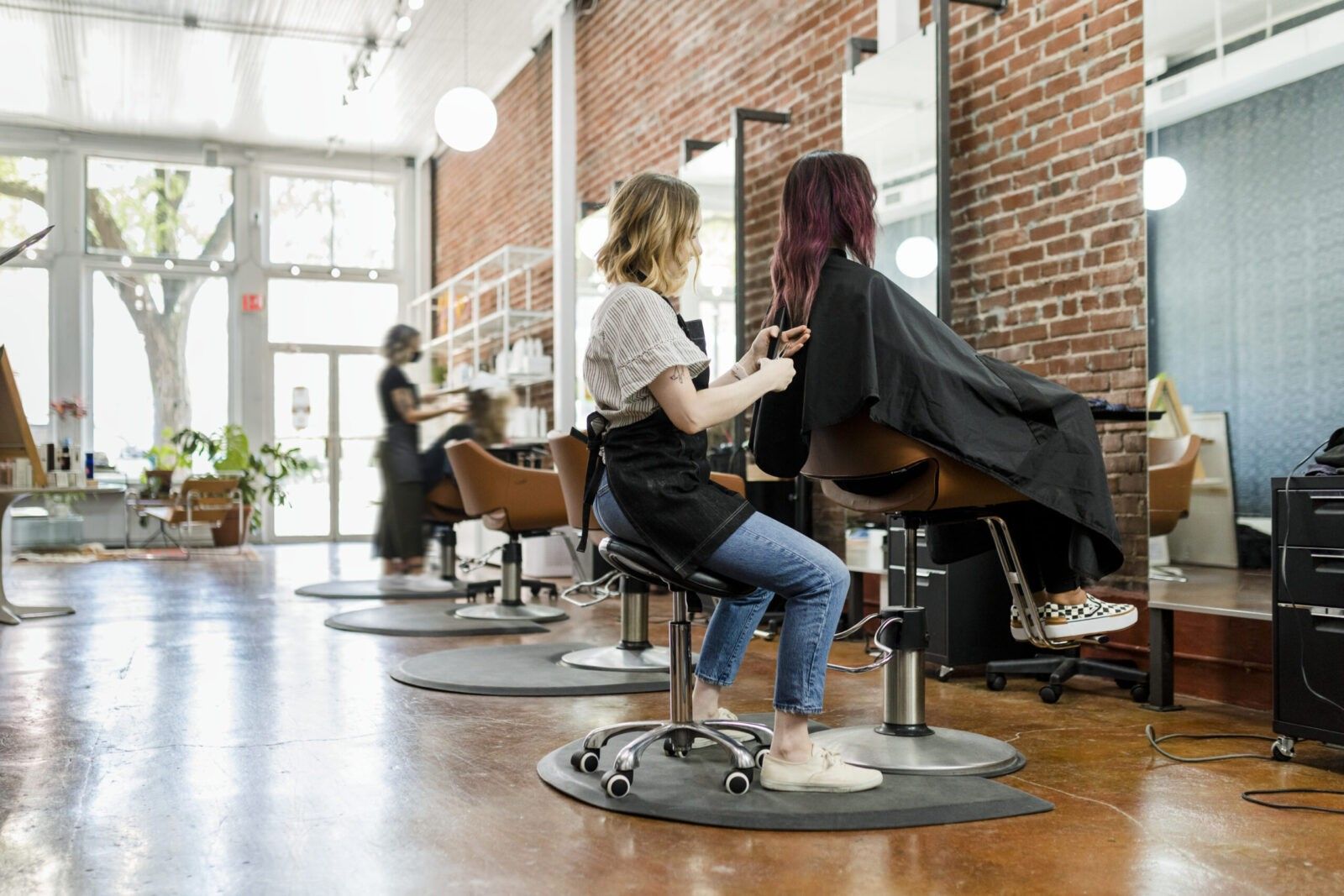 Estilista cortando el cabello de un cliente en salón de belleza