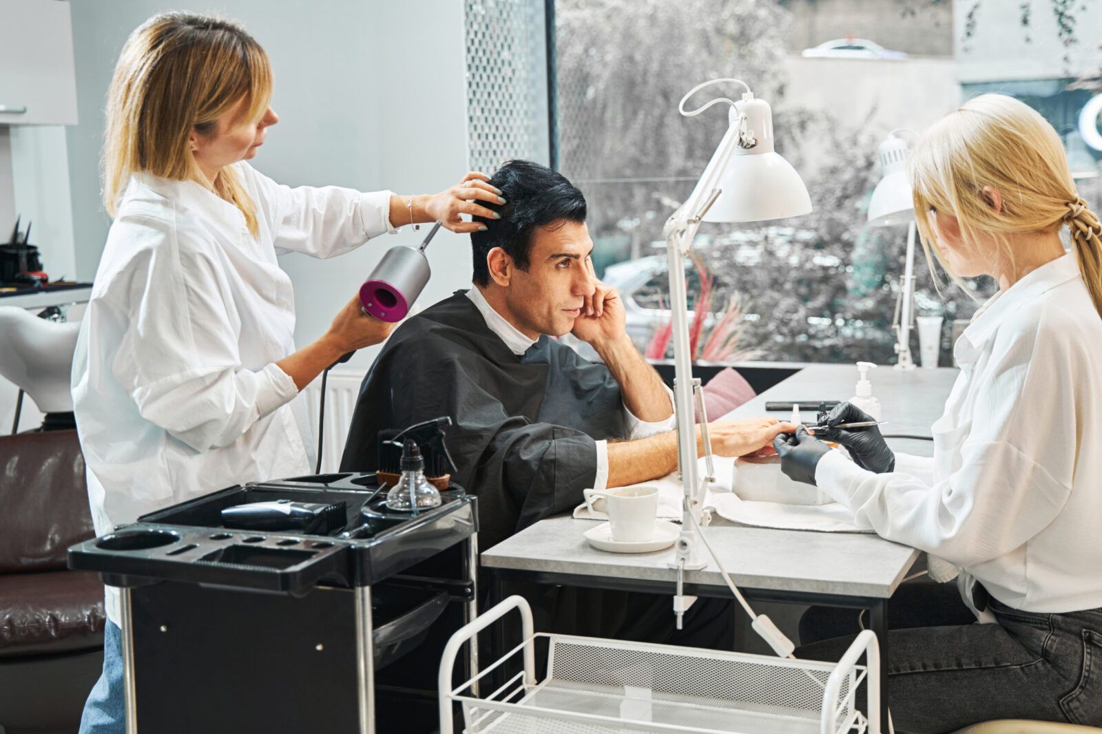Cliente recibiendo tratamiento de uñas y cabello en salón de belleza